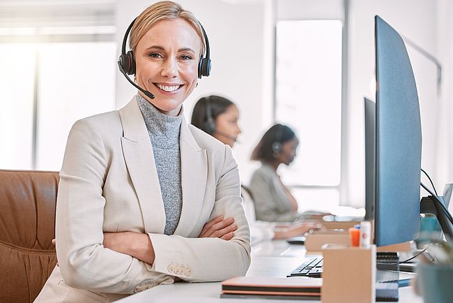 Lächelnde junge Frau bei der Arbeit am Laptop