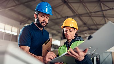 Zwei internationale Ingenieure arbeiten in einer Fabrik